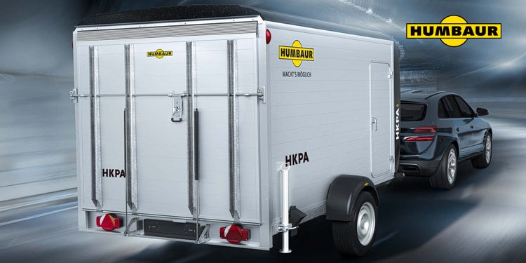 Humbaur Kofferanhänger HKPA an SUV auf moderner Straße.