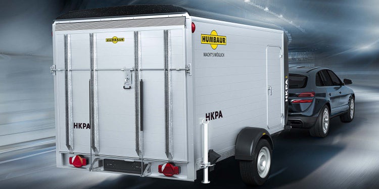 Humbaur Kofferanhänger HKPA an SUV auf moderner Straße.