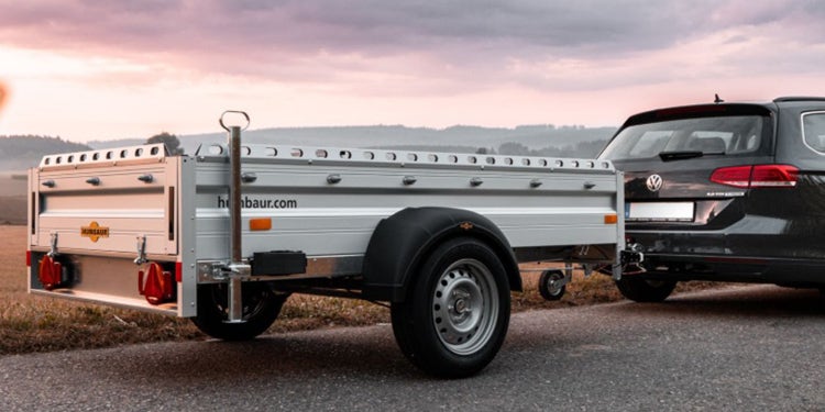 Humbaur Anhänger am VW Golf auf Landstraße bei Sonnenuntergang